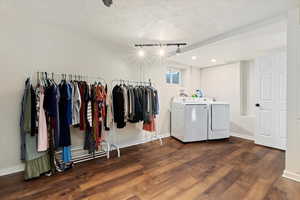 Laundry area with washer and dryer, dark wood-type flooring, and a textured ceiling