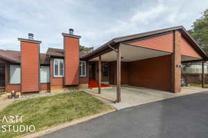 View of front facade featuring a front lawn and a carport