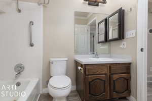 Full bathroom with tiled shower / bath combo, vanity, crown molding, hardwood / wood-style flooring, and toilet