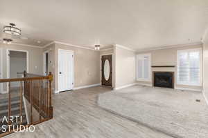 Unfurnished living room featuring hardwood / wood-style flooring and ornamental molding