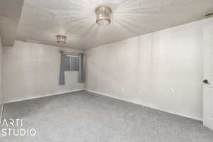 Carpeted empty room featuring a textured ceiling