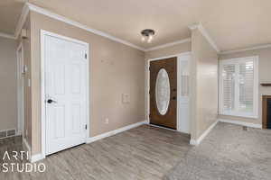 Foyer entrance featuring light wood-type flooring and ornamental molding