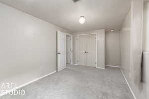 Unfurnished bedroom with carpet, a textured ceiling, and a closet