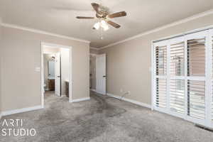 Unfurnished bedroom featuring carpet flooring, a textured ceiling, ceiling fan, and ornamental molding