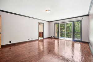 Master bedroom with sliding doors to balcony overlooking wooded lot. Featurning hand scraped hardwood floors, and crown molding