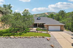 View of front of house featuring a mountain view, a garage, and a front yard