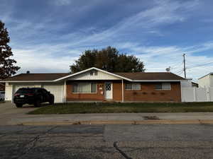 Single story home featuring a garage and a front yard