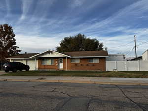 Ranch-style house with a front lawn and a garage