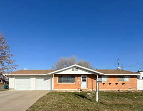 Ranch-style home with a garage and a front lawn