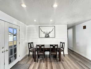 Dining area featuring french doors, a textured ceiling, and hardwood / wood-style flooring