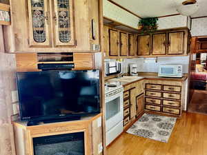 Kitchen featuring light wood-type flooring, white appliances, and sink