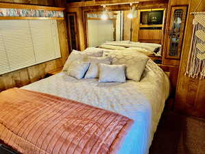 Carpeted bedroom with wood walls