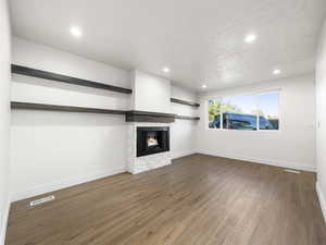 Unfurnished living room with dark hardwood / wood-style flooring and a textured ceiling