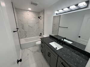 Full bathroom featuring vanity, toilet, and tiled shower / bath