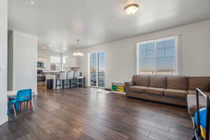 Living room featuring sink, a notable chandelier, and dark hardwood / wood-style floors