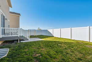 View of yard with a deck and a trampoline