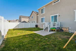 Rear view of house with a yard and a patio area