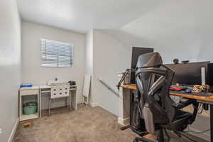 Office featuring light colored carpet and vaulted ceiling