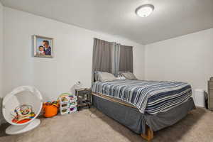 Carpeted bedroom featuring a textured ceiling