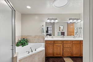 Bathroom with tile patterned flooring, vanity, and separate shower and tub