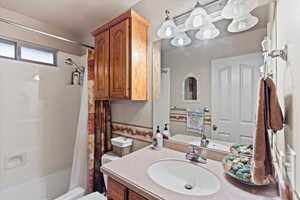 Full bathroom with vanity, toilet, and shower / bathtub combination with curtain