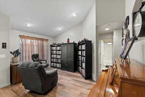 Living room with light hardwood / wood-style flooring and lofted ceiling