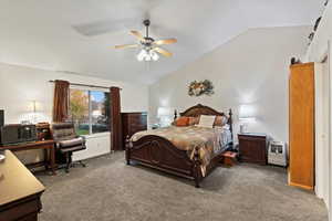 Carpeted bedroom with ceiling fan and vaulted ceiling