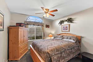 Carpeted bedroom featuring ceiling fan