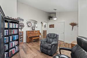 Sitting room featuring high vaulted ceiling, wood-type flooring, and a notable chandelier