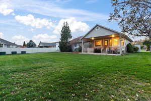 Back of house with a lawn and a patio area