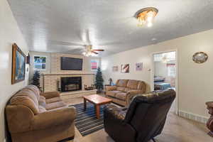 Carpeted living room featuring a textured ceiling and plenty of natural light