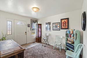 Tiled foyer entrance with a textured ceiling