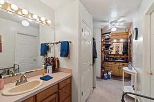 Bathroom featuring ceiling fan, vanity, and a textured ceiling