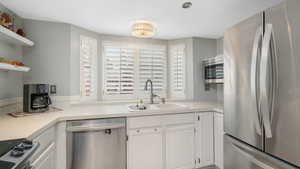 Kitchen featuring white cabinetry, sink, and stainless steel appliances