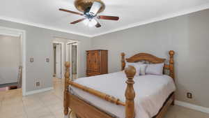 Bedroom featuring ceiling fan, crown molding, and light tile patterned floors