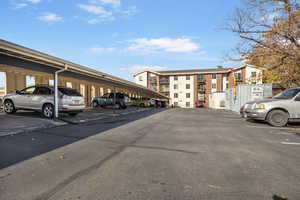 View of parking / parking lot featuring a carport