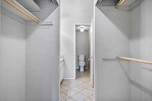 Primary bedroom closet leading into ensuite bathroom