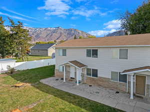 Front of property with a mountain view and a yard