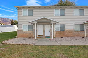 View of front of house featuring a mountain view and a front yard