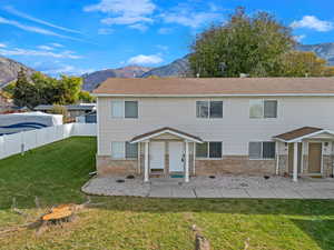 Front view of house with a lawn and a mountain view