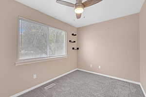 Spare room featuring carpet and ceiling fan