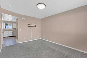 Empty room with carpet, a textured ceiling