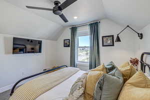 Bedroom with carpet floors, ceiling fan, and lofted ceiling