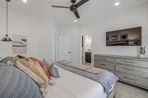 Bedroom featuring connected bathroom, light colored carpet, and ceiling fan