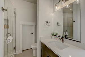 Bathroom featuring tile patterned flooring, vanity, and toilet