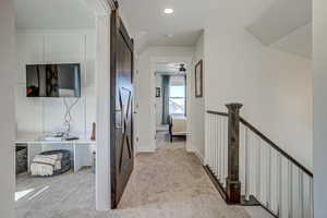 Hall featuring light carpet and a barn door