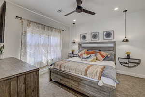 Carpeted bedroom featuring ceiling fan