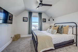 Bedroom with ceiling fan, carpet, and vaulted ceiling