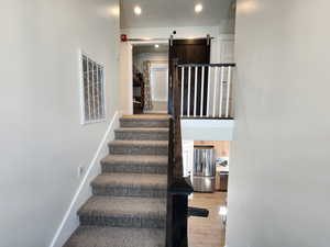 Stairs featuring a barn door and wood-type flooring