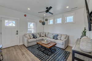 Living room featuring ceiling fan and light wood-type flooring